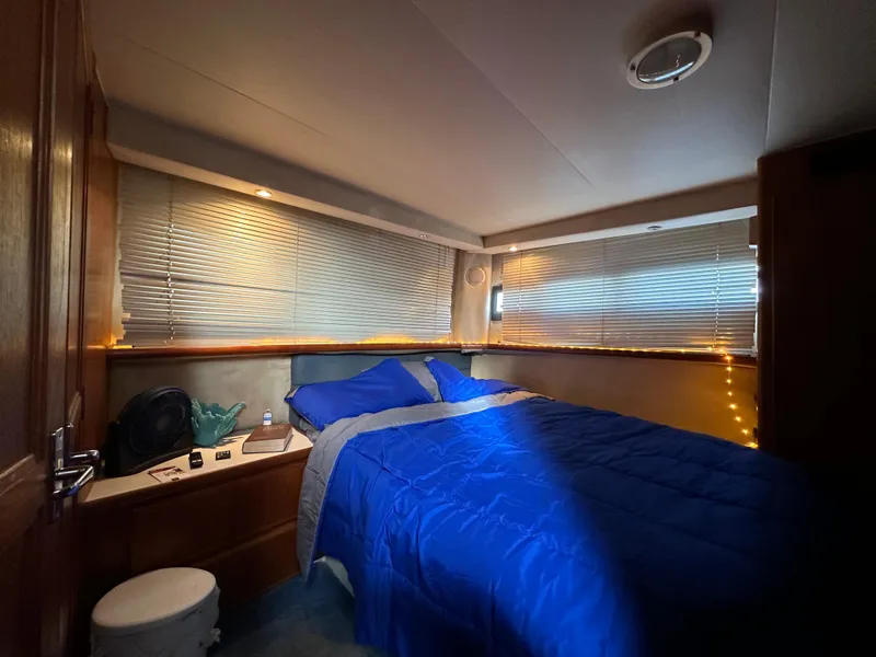Slide: The Image of Cozy bedroom in 1994 Carver 350 Aft Cabin Motor Yacht with blue bedding and ambient lighting. - 20