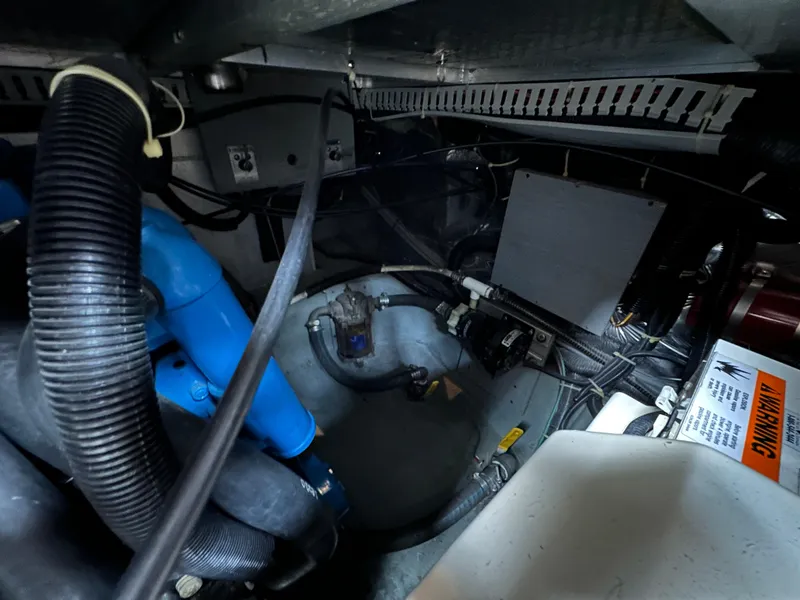 Slide: The Image of Engine room of 1994 Carver 350 Aft Cabin Motor Yacht with visible hoses and components. - 26