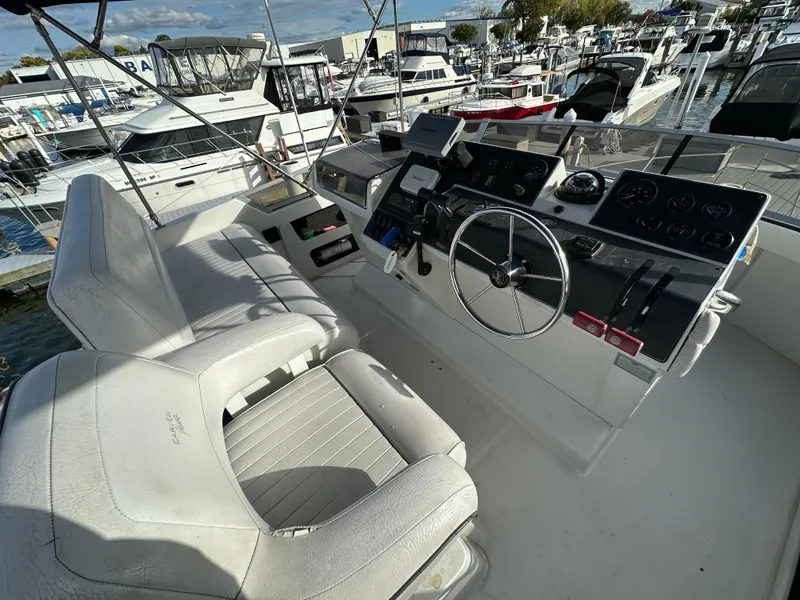 Slide: The Image of 1994 Carver 350 Aft Cabin Motor Yacht helm with dual seats and control panel. - 6