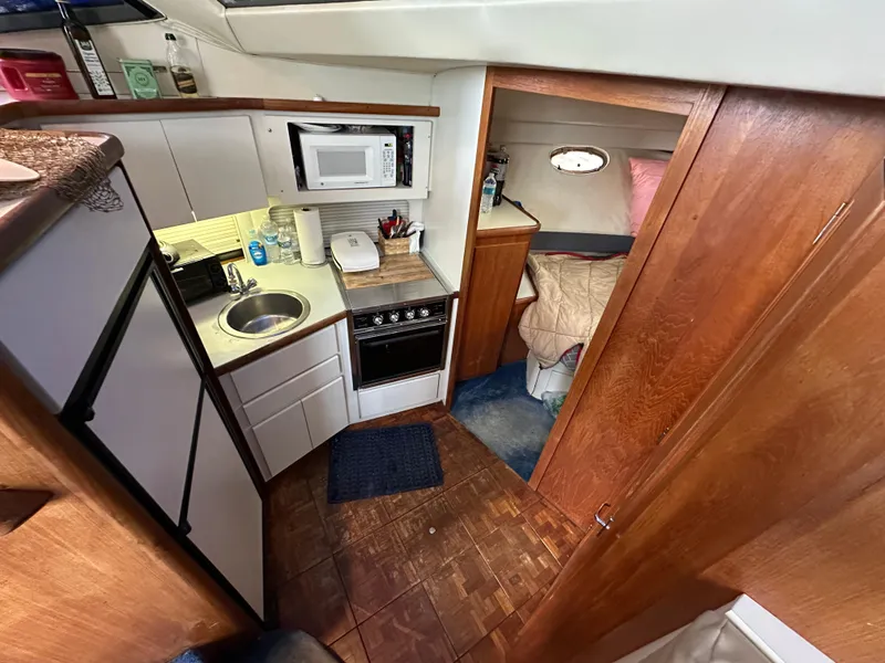 Slide: The Image of 1994 Carver 350 Aft Cabin Motor Yacht interior with kitchenette and cozy sleeping area. - 15