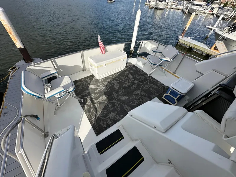 Slide: The Image of 1994 Carver 350 Aft Cabin Motor Yacht deck with seating, table, and marina view. - 3
