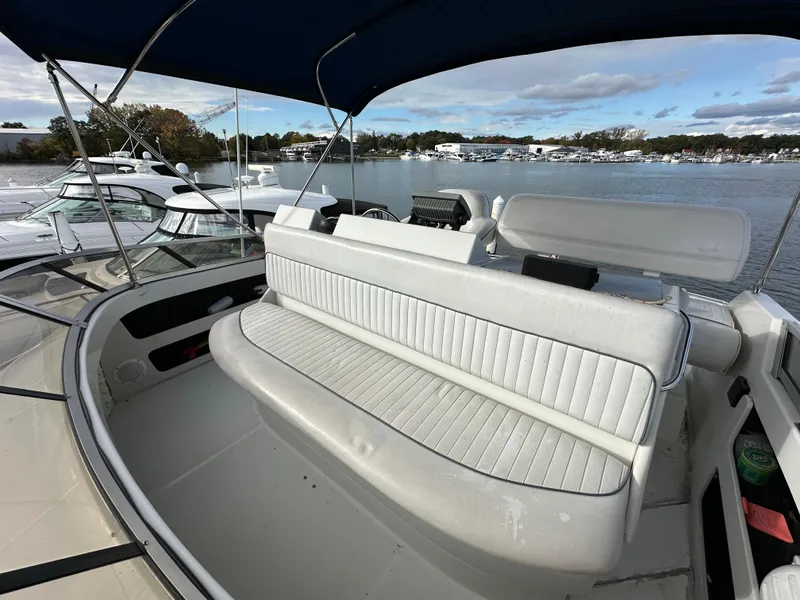 Slide: The Image of 1994 Carver 350 Aft Cabin Motor Yacht with spacious seating, docked by a serene waterfront. - 9