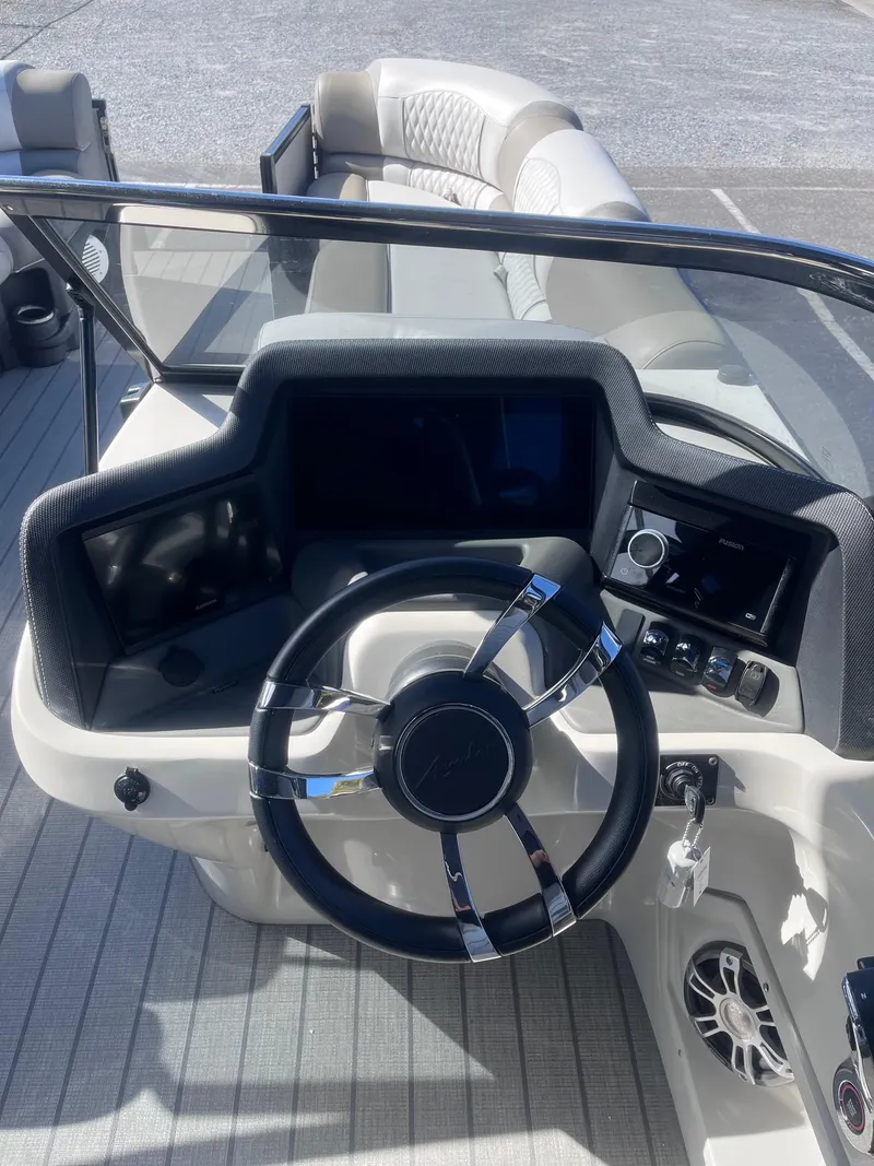 Slide: The Image of 2023 Avalon Excalibur Elite boat dashboard with steering wheel and controls. - 11
