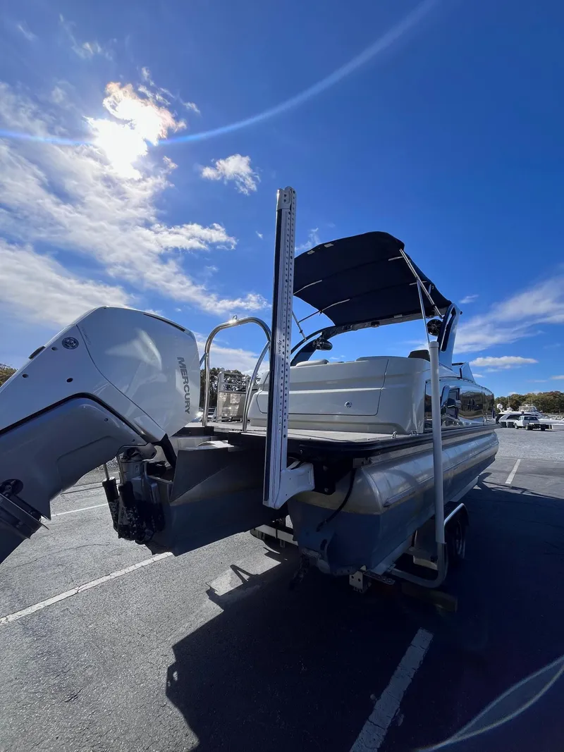 Slide: The Image of 2023 Avalon Excalibur Elite Windshield boat, 27-foot, parked under a clear blue sky. - 4