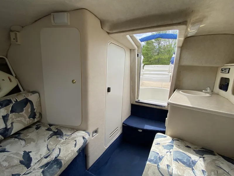 Slide: The Image of Interior of 2000 Sea Ray 245 Weekender boat with seating and compact kitchenette. - 7