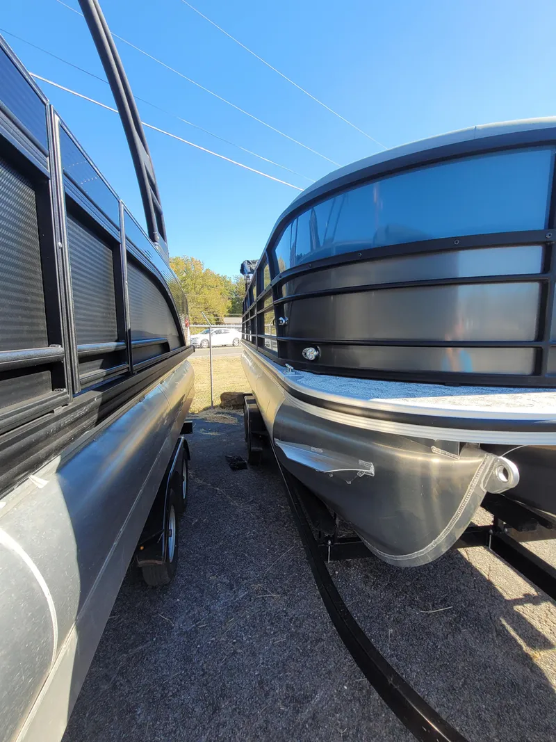 Slide: The Image of 2025 Trifecta 24ULLET275 pontoon boats side by side under clear blue sky. - 2