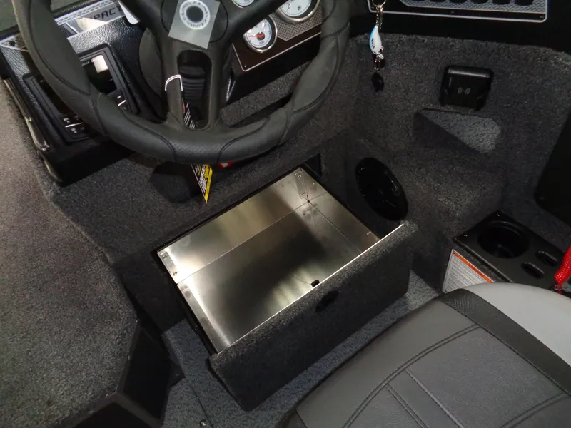 Slide: The Image of 2025 Lund 1875 Impact XS Sport boat interior with steering wheel and storage compartment. - 21