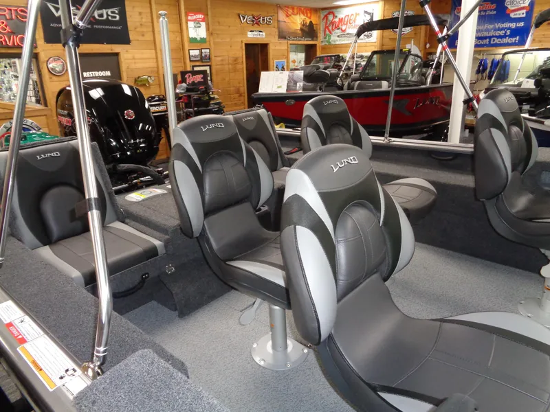 Slide: The Image of 2025 Lund 1875 Impact XS Sport boat interior with comfortable seating in showroom. - 25