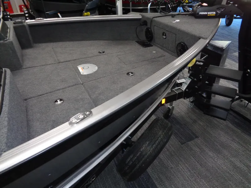 Slide: The Image of 2025 Lund 1875 Impact XS Sport boat interior with carpeted deck and storage compartments. - 3