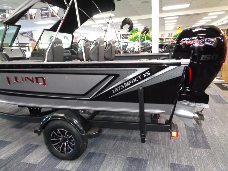 Slide: The Image of 2025 Lund 1875 Impact XS Sport boat displayed indoors with Mercury Pro XS engine. - 8