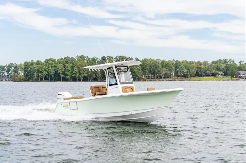 Slide: The Image of 2025 Sea Hunt Ultra 235 SE boat cruising on a lake with trees in the background. - 12