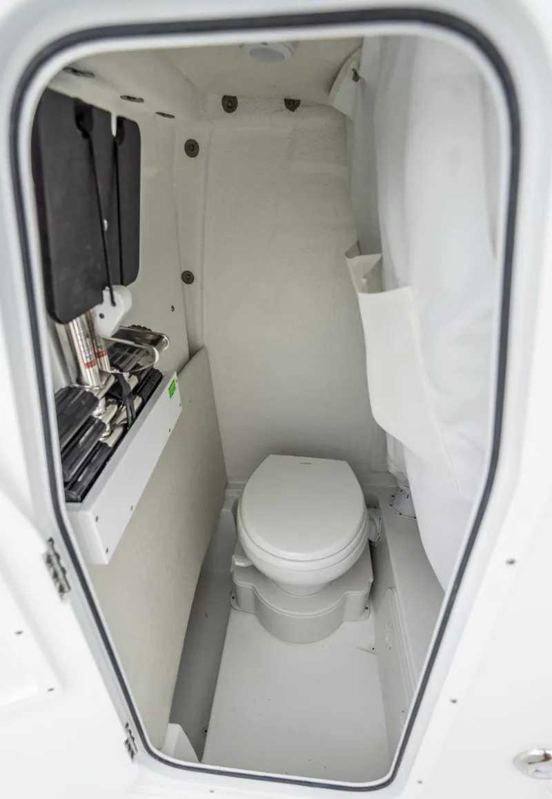 Slide: The Image of 2025 Sea Hunt Ultra 235 SE boat interior with compact marine toilet. - 18