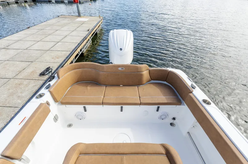 Slide: The Image of 2025 Sea Hunt Ultra 235 SE boat interior with tan seating at dock. - 8