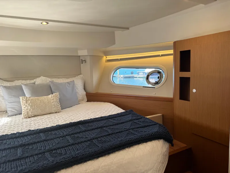 Slide: The Image of 2020 Beneteau Swift Trawler 41 Fly cabin with cozy bed and porthole view. - 11
