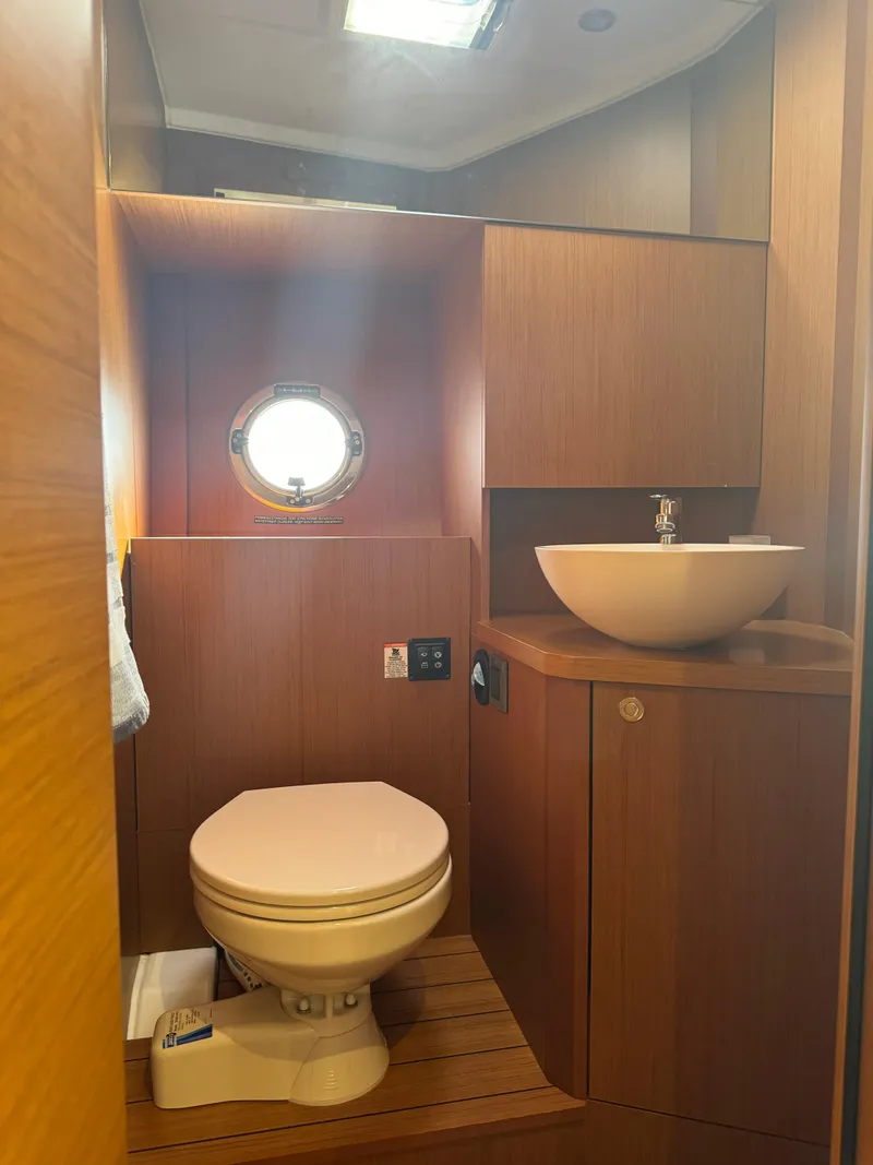 Slide: The Image of 2020 Beneteau Swift Trawler 41 Fly bathroom with wooden interior and modern fixtures. - 14