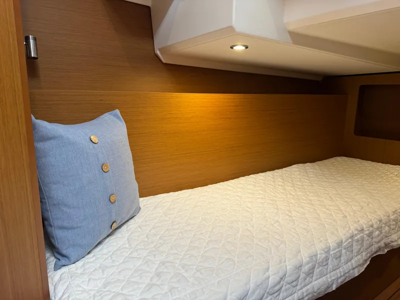Slide: The Image of Cozy cabin interior of 2020 Beneteau Swift Trawler 41 Fly with blue pillow and quilted bedding. - 18