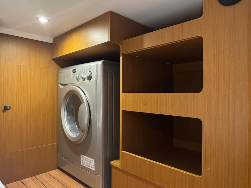 Slide: The Image of Laundry area in 2020 Beneteau Swift Trawler 41 Fly with washer and wooden shelves. - 19