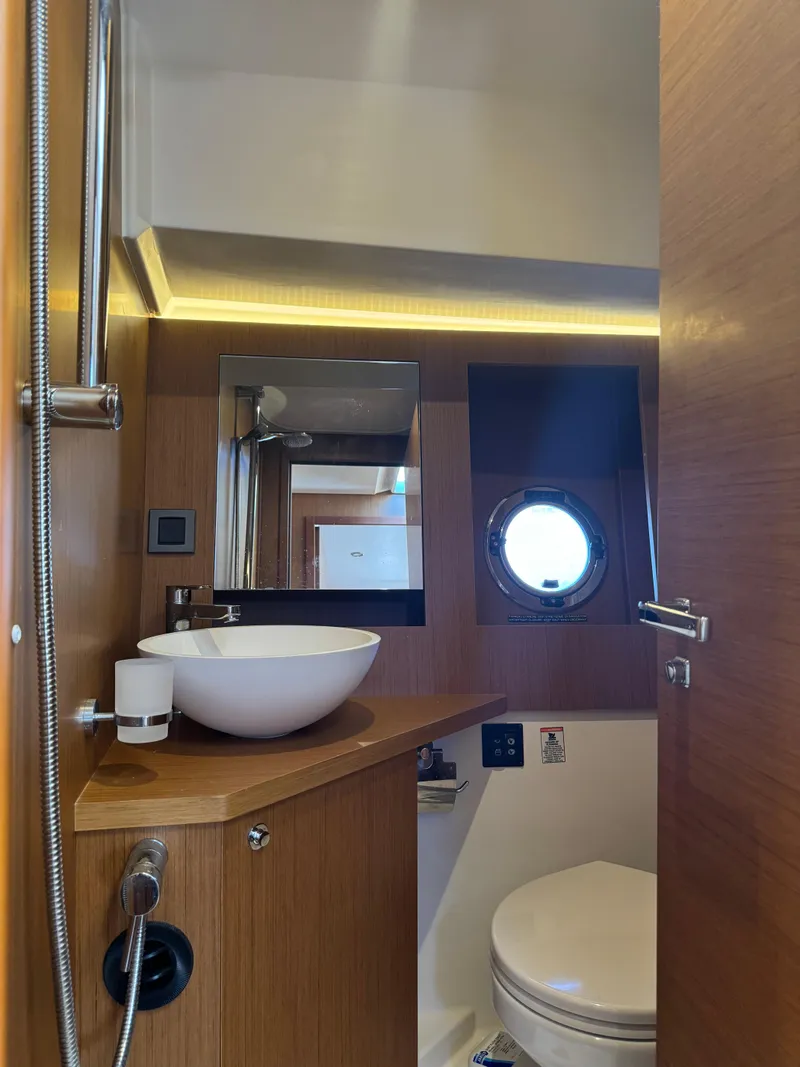 Slide: The Image of 2020 Beneteau Swift Trawler 41 Fly bathroom with modern fixtures and porthole window. - 21
