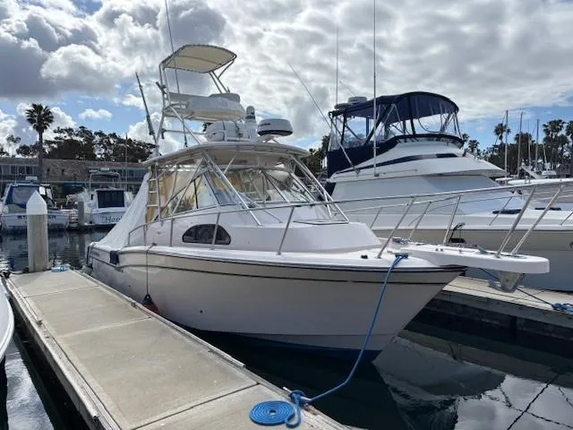 Slide: The Image of 2009 Grady-White Marlin 300 boat docked at marina under cloudy sky. - 0