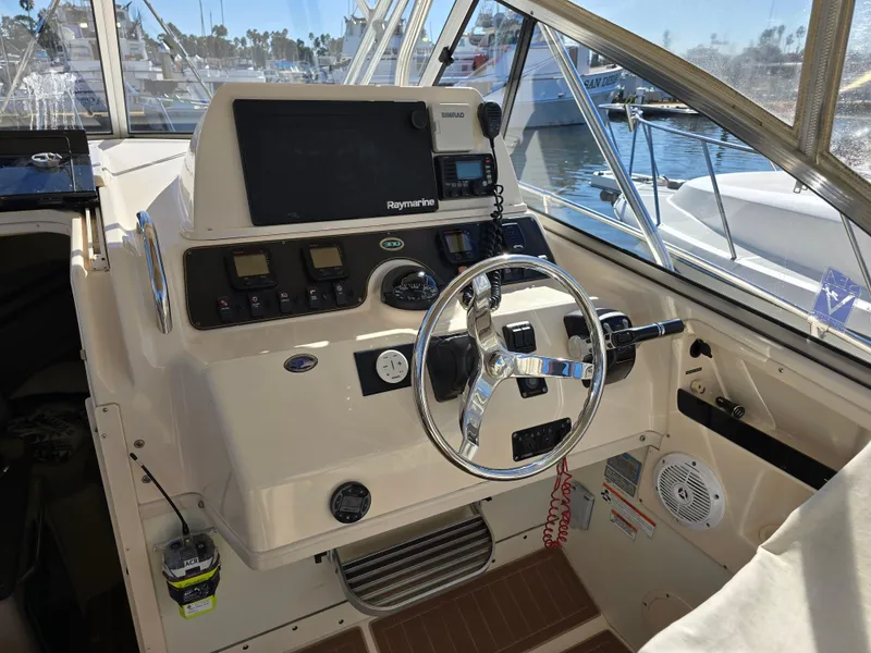 Slide: The Image of 2009 Grady-White Marlin 300 helm with steering wheel and navigation equipment. - 18