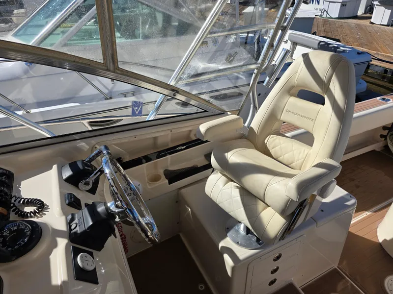 Slide: The Image of 2009 Grady-White Marlin 300 helm with beige captain's chair and steering wheel. - 19