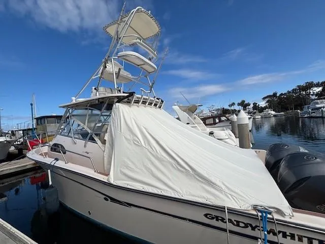 Slide: The Image of 2009 Grady-White Marlin 300 boat docked at marina under clear blue sky. - 2
