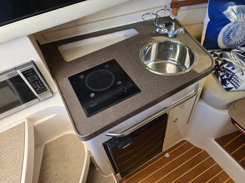 Slide: The Image of 2009 Grady-White Marlin 300 boat interior with kitchenette, sink, and stove. - 32