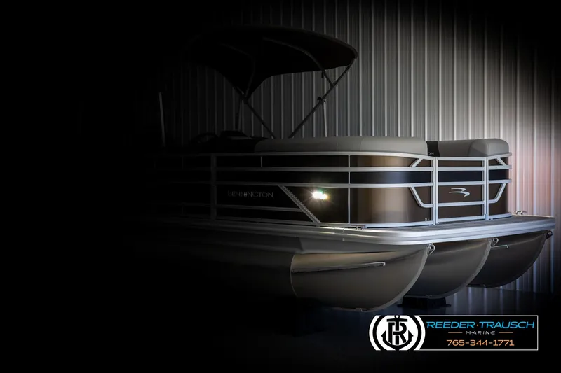 Slide: The Image of 2025 Bennington 21 SLSE pontoon boat in dimly lit showroom. - 4