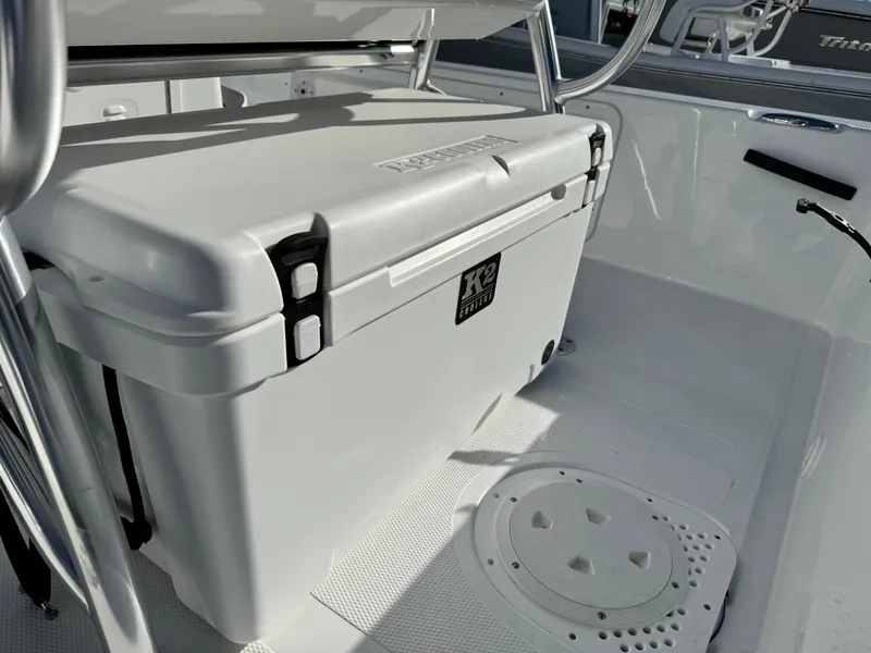 Slide: The Image of 2025 Frontier 2104 boat interior with dual seats and motor, parked on concrete. - 24