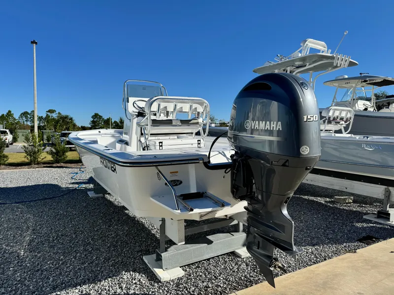 Slide: The Image of 2025 Frontier 2104 boat on trailer at marina under clear blue sky. - 4