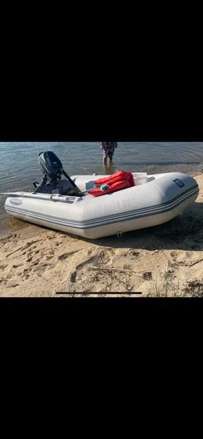 The Image of Inflatable boat on sandy shore with outboard motor, Luhrs 320 Tournament, 1989 model. - 16