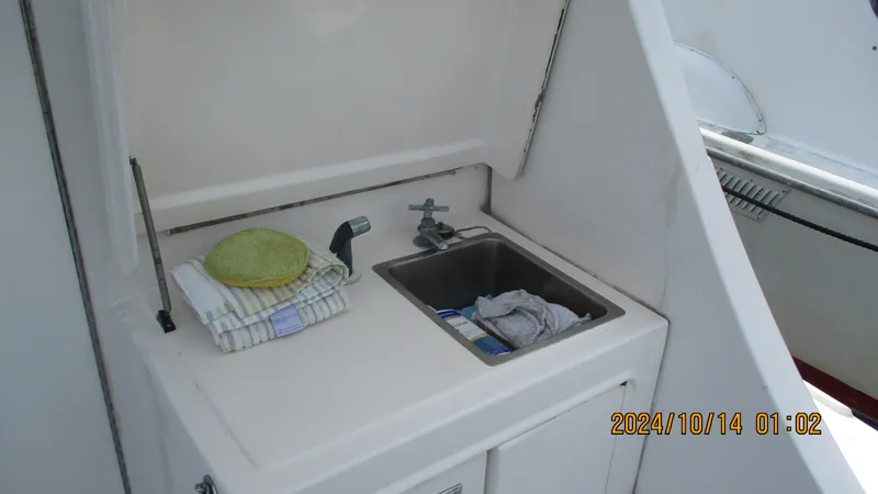 Slide: The Image of 1989 Luhrs 320 Tournament boat sink area with cleaning supplies. - 1