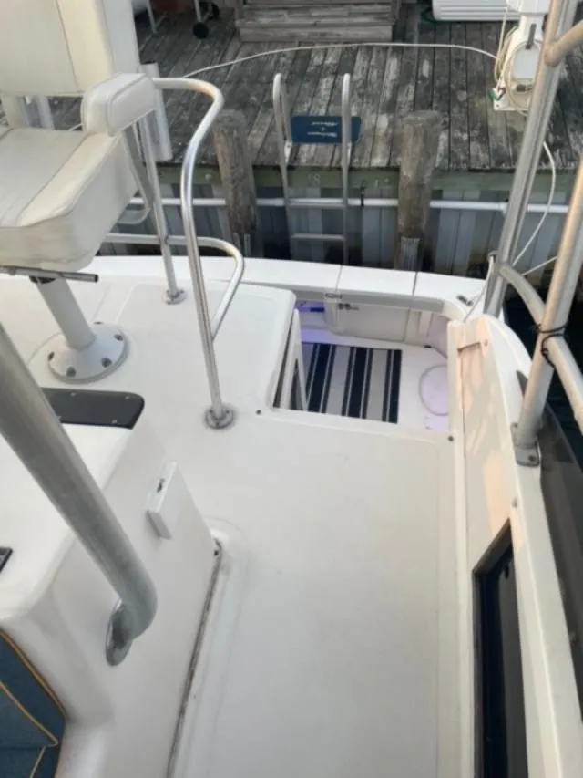 Slide: The Image of 1989 Luhrs 320 Tournament boat deck with seating and railing, docked at a wooden pier. - 4