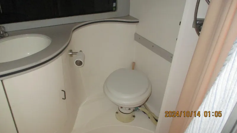 Slide: The Image of 1989 Luhrs 320 Tournament boat bathroom with sink and toilet. - 15
