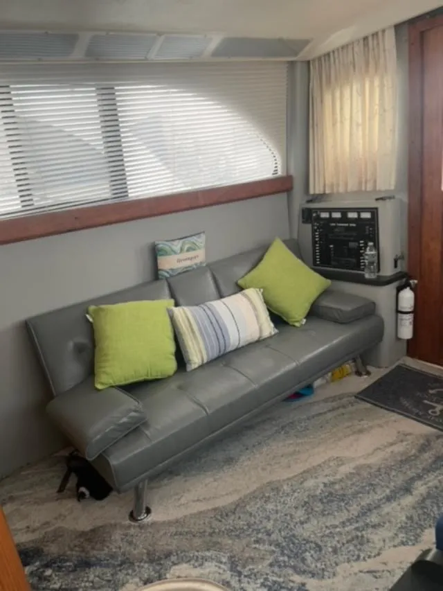 Slide: The Image of 1989 Luhrs 320 Tournament interior with gray sofa, colorful pillows, and nautical decor. - 12