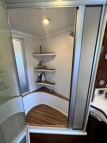 Slide: The Image of Luxurious 2005 Marquis 65 yacht shower with wooden floor and corner shelves. - 17