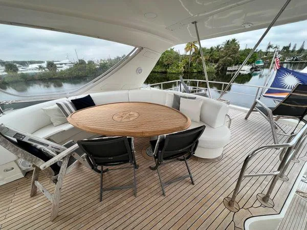 Slide: The Image of Luxurious 2005 Marquis 65 yacht deck with elegant seating and wooden table. - 23