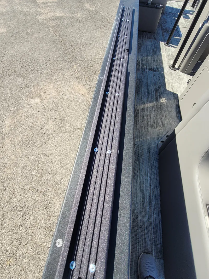 Slide: The Image of 2025 Quest M-8524 Angler Series boat deck with rod holders and seating area. - 22