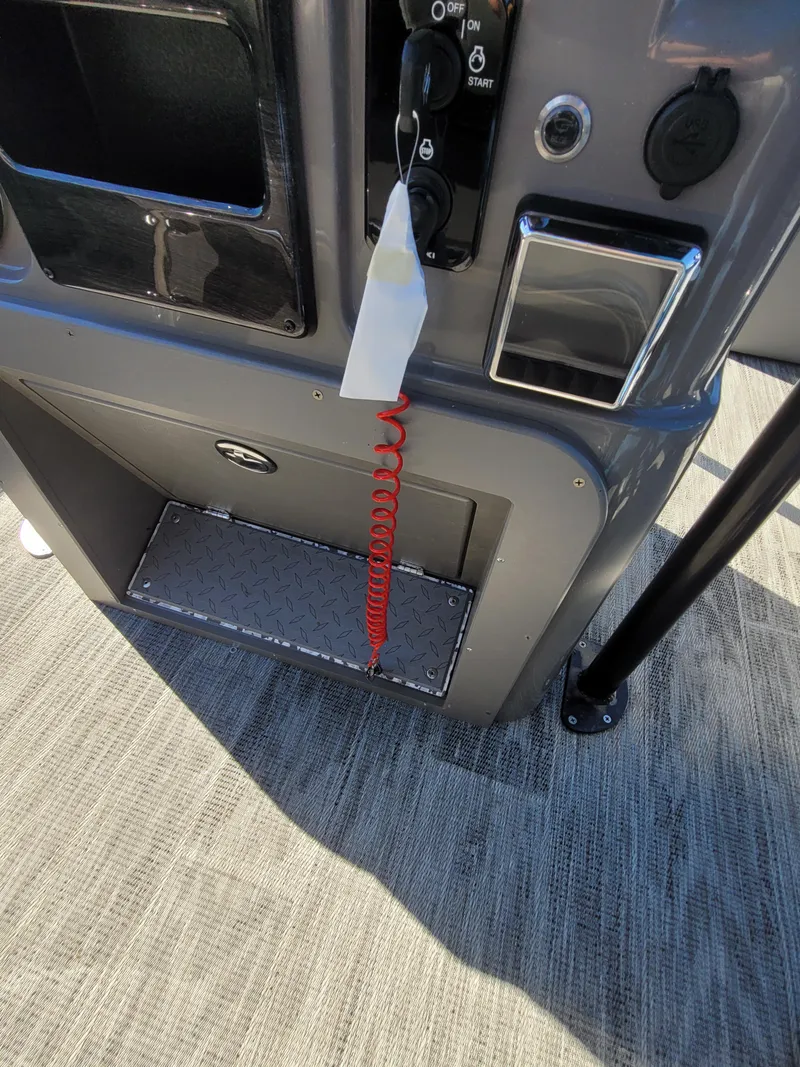 Slide: The Image of 2025 Quest M-8524 Angler Series boat dashboard with controls and red safety cord. - 27