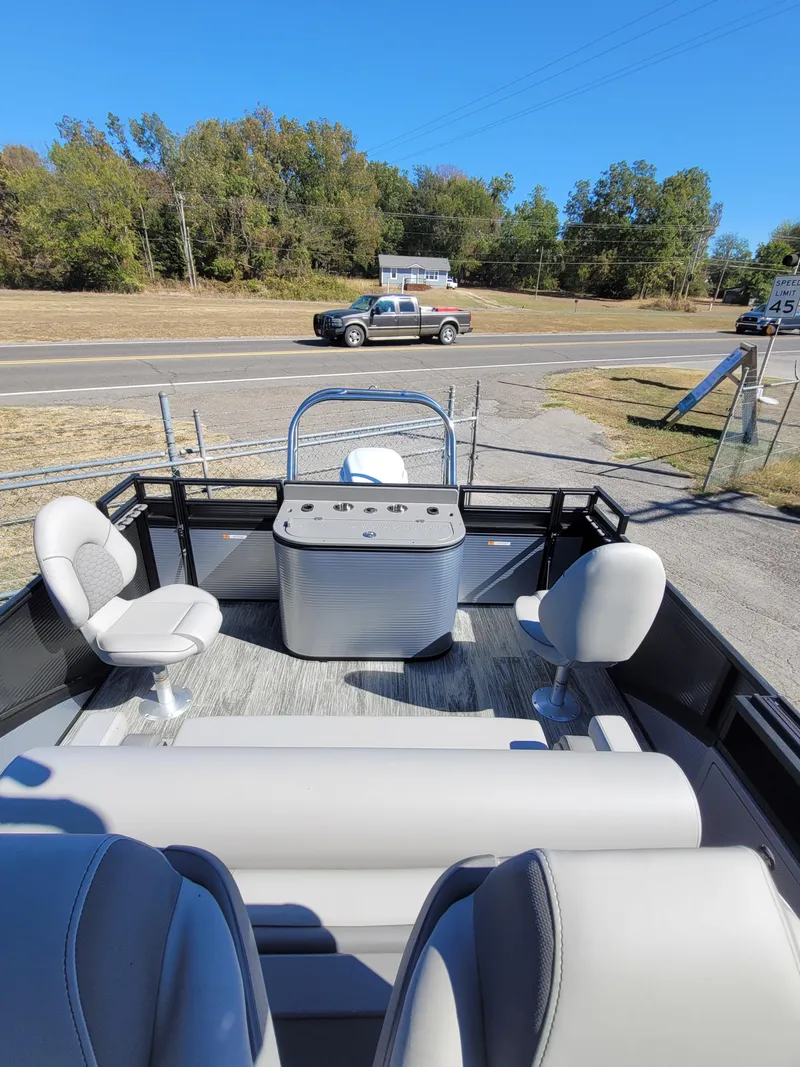 Slide: The Image of 2025 Quest M-8524 Angler Series boat interior with seating and console, parked near a road. - 32