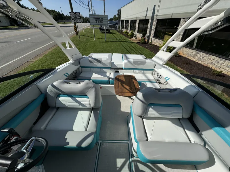 Slide: The Image of Interior of 2025 Regal LS2 boat with modern seating and wooden table. - 11