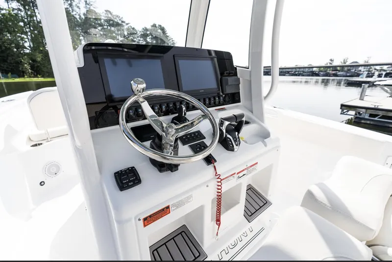 Slide: The Image of 2025 Sea Hunt Ultra 275 SE boat dashboard with steering wheel and navigation screens. - 29