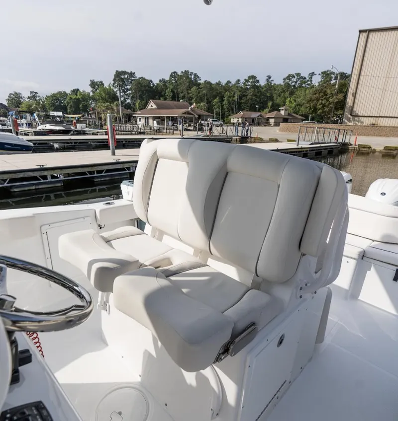 Slide: The Image of 2025 Sea Hunt Ultra 275 SE boat with plush white seating at a marina. - 39