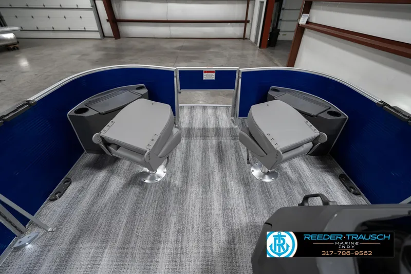 Slide: The Image of 2025 Bennington 168SF boat interior with blue and gray seating in a showroom. - 19