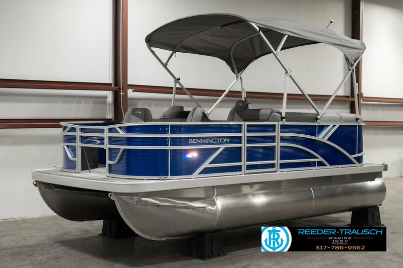 Slide: The Image of 2025 Bennington 168SF pontoon boat with blue exterior and canopy in showroom. - 3