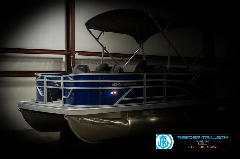 Slide: The Image of 2025 Bennington 168SF pontoon boat in a dimly lit showroom. - 4