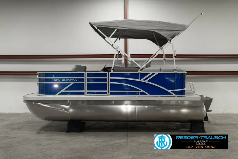 Slide: The Image of 2025 Bennington 168SF pontoon boat with blue exterior and canopy in showroom. - 5