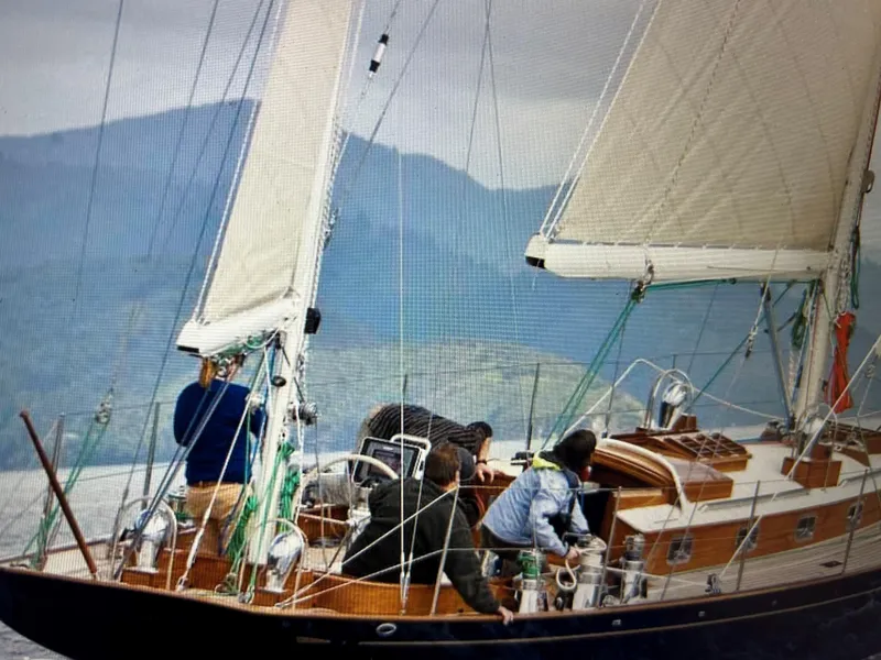 Slide: The Image of Sailing on a 2010 Sparkman & Stephens S&S 45 yacht with crew, against a mountainous backdrop. - 12