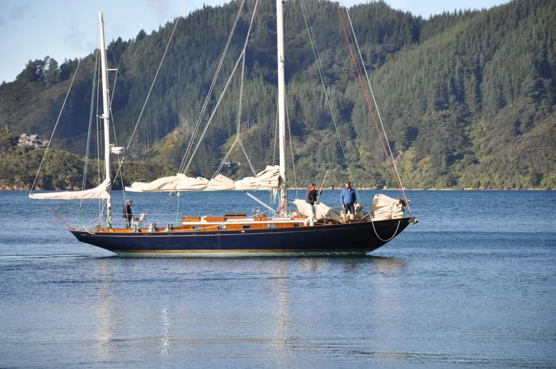 Slide: The Image of Sailing yacht Sparkman & Stephens S&S 45, 2010 model, on serene water with forested hills. - 22