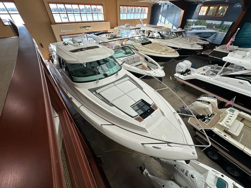 Slide: The Image of 2022 Tiara Yachts 43 LE in showroom, surrounded by other luxury boats. - 2